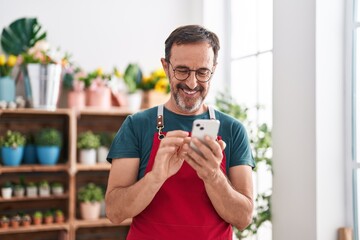 Sticker - Middle age man florist smiling confident using smartphone at florist