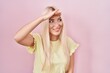 © Krakenimages.com - Caucasian woman standing over pink background very happy and smiling looking far away with hand over head. searching concept.