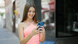 © Krakenimages.com - Young beautiful girl using smartphone smiling at street