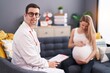 © Krakenimages.com - Man and woman doctor and pregnant patient having medical consultation at home