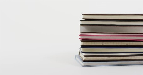 Sticker - Close up of stack of books on white background, in slow motion