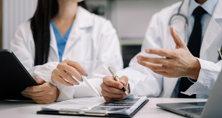 Doctors working together on digital tablet healthcare doctor technology tablet using computer in a modern office.