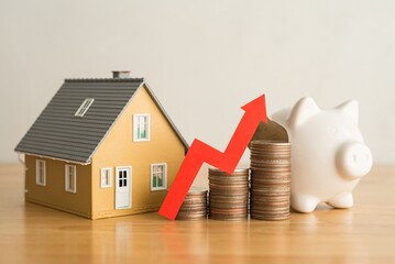 Red graph chart rising up on stack coins house model and piggy bank on wooden table white wall background. Concept of money management for mortage loan, education, insurance, retirement and investment