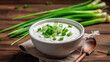 Fresh sour cream in bowl with green onions On a wooden background. Generative AI
