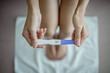 Close-up of young woman holds a pregnancy test in her hands. Positive pregnancy test.