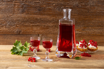 Wall Mural - Delicious homemade currant liqueur. Served in a glass and carafe. Served with currant cake.