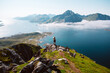 © BublikHaus - Silhouette of a hiker woman stand on top of mountain hike summit overlooking epic Lofoten Archipelago landscape. Inspiring and amazing idea of adventure. Roadtrip in Norway