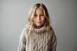 © Hanne Bauer - Portrait of a beautiful little girl in a warm sweater on a gray background