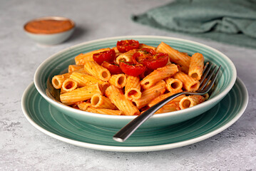 Wall Mural - Food photography of pasta, rigatoni with  roasted tomatoes, sauce, olive oil, durum, wheat, semolina, fork, background, italian