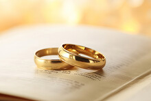 A Pair Of Gold Wedding Rings On A Prayer Book