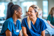 © MVProductions - Candid shot of two nurses laughing and talking in a hospital, showcasing positivity and collegiality. Generative AI
