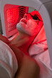 Woman getting facial treatment with led therapy.