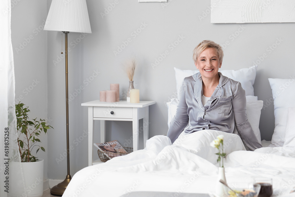 Mature woman waking up in bedroom
