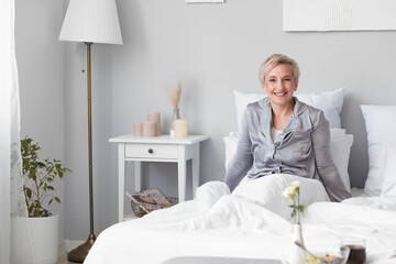 Wall Mural - Mature woman waking up in bedroom