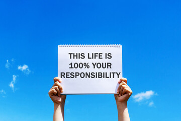Wall Mural - Hands holding a placard with inspirational quotes - This life is 100% your responsibility
