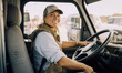 © MVProductions - Candid shot of a confident caucasian female delivery truck driver. Generative AI