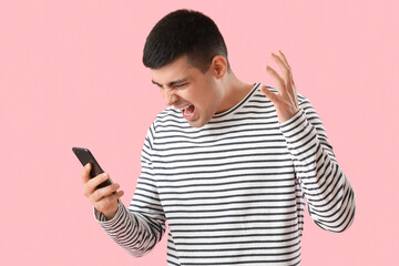 Poster - Aggressive young man with smartphone on pink background