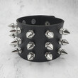 Black leather bracelet with spikes, holnitenes. An accessory for rockers, bikers, metalheads, goths and punks. Steampunk style. Close-up subject photography.