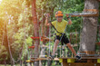 © Daniel CHETRONI - Boy enjoys climbing in the ropes course adventure. Happy boys playing at adventure park holding ropes and climbing wooden stairs