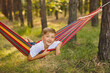 © Inna Vlasova - Cute little blond caucasian boy having fun with multicolored hammock