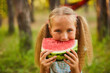 © Inna Vlasova - Cute girl eating watermelon at park in the forest
