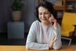 Happy middle aged senior woman talking on smartphone with family friends. Older mature lady with cell phone chatting with grown up children, resting in at home. Older generation modern tech usage