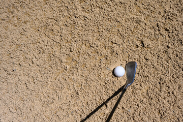 Wall Mural - Standing in the sand trap, golf ball in the sand and sand wedge golf club ready to hit out of the bunker, recreation and challenge on a sunny summer day
