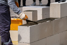 The Bricklayer Is Working. Building A Wall Of Aerated Concrete. Gasbeton Wall