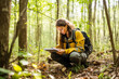 Leinwandbild Motiv Female environmental conservation surveyor in the forest, recording data as part of field research, showcasing commitment to preserving nature and sustainability