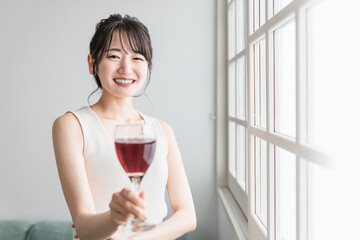 Poster - 家で赤い飲み物を昼飲みするアジア人女性（赤ワイン・アセロラ・ザクロ・シソ・ポリフェノール・タンニン）
