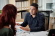 © DragonImages - Businessman having emotional conversation with coworker after finishing work on report