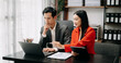 © Nuttapong punna - Asian business colleague business presents and explains and using laptop and tablet. Teamwork, financial marketing team,   while sitting in office room.