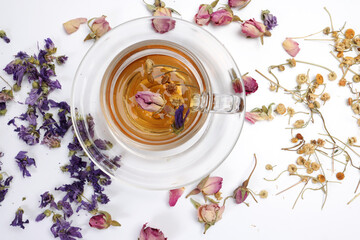 Wall Mural - Dry flower tea rose bud butterfly pea chamomile flower transparent ceramic glass tea cup on white background