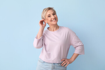 Wall Mural - Mature blonde woman on blue background