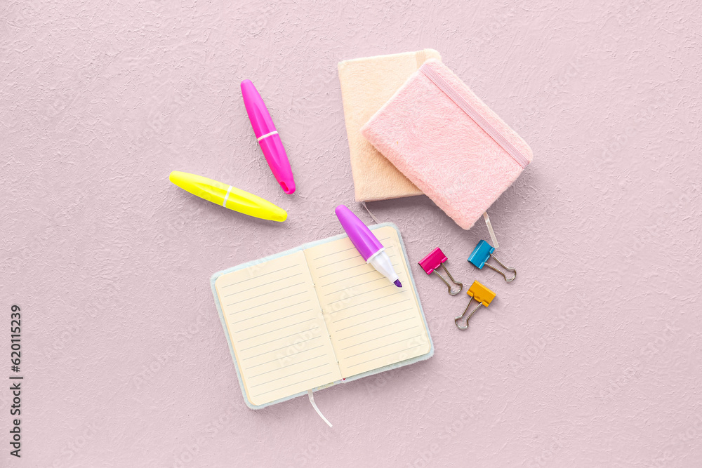 Composition with notebooks, markers and binder clips on light background