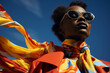 Portrait of woman in sunglasses wearing yellow scarf and red leather jacket on blue sky background. Confident inspiring high fashion female model