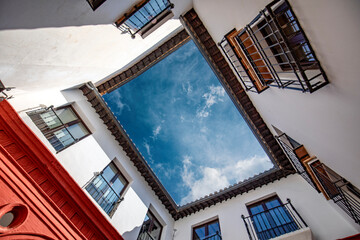 Canvas Print - One of the inner courtyards of El Palacio de Mondragón, historic Mudejar-Renaissance building located in the old town of Ronda, Malaga, Spain with the sky above