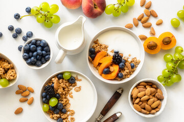 two healthy breakfast bowl with ingredients granola fruits greek yogurt and berries top view. weight