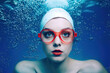 Young woman with red swimming goggles underwater 