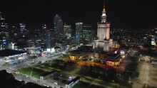 Aerial Shot Of Warsaw Modern City Business Center At Night Seen From The Open Window,drone Moving Out From Inside The Room