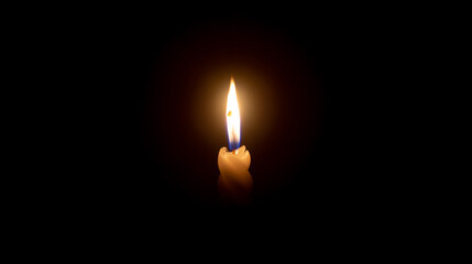 A single burning candle flame or light glowing on a white spiral candle on black or dark background on table in church for Christmas, funeral or memorial service with copy space.