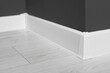 © New Africa - White plinth with connector on laminated floor near black wall indoors, closeup