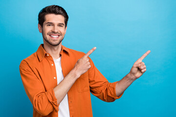 Fototapete - Portrait of nice cheerful person toothy smile direct fingers empty space offer novelty isolated on blue color background