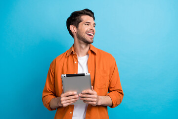 Aufkleber - Photo of positive excited guy wear orange shirt texting modern device looking empty space isolated blue color background
