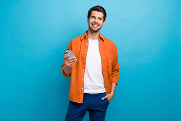 Fototapete - Portrait of positive nice person toothy smile hold use apple iphone texting chatting isolated on blue color background