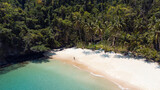 Fototapeta  - Podróżnik idący po pięknej plaży, rajska wyspa z palmami i turkusowa woda.