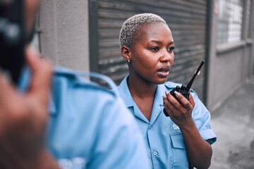 security, walkie talkie and a police woman in the city during her patrol for safety or law enforceme