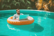 A man on an inflatable circle with a laptop in the pool. The concept of remote work