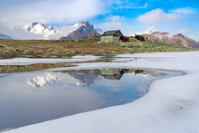 Mountain Hut On Shore Of Frozen Pond During Thaw, Scermendone Alp, Rhaetian Alps, Valtellina, Lombardy
