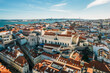 © robertharding - Aerial drone view of Carmo Church and surrounding historic neighbourhood in Chiado, with Tagus River and 25 April Bridge visible, Lisbon, Portugal